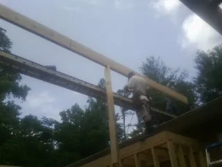 Carpenter setting a ridge beam over a new addition frame — Ice Dam Removal by Roofing Brothers in Woodsville