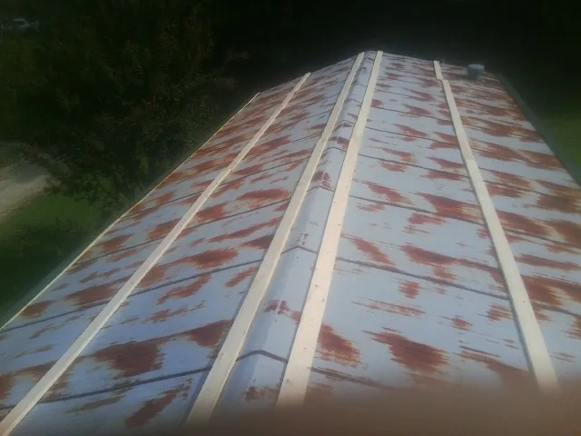 Rusted metal roof panels with new wood purlins before replacement — Storm Damage Roof Repair in Woodsville by Roofing Brothers